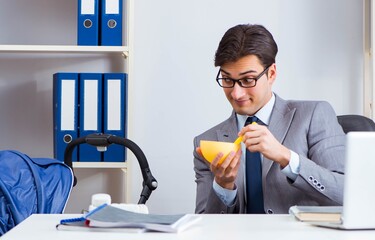 Businessman looking after newborn baby in office