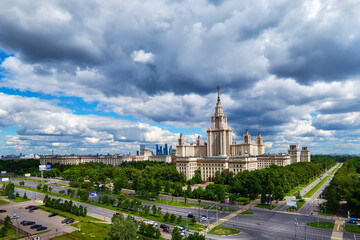 Aerial panoramic view of sunny campus buildings of famous Moscow university under dramatic cloudy sky in spring