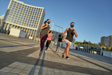 Obraz premium Young mixed race athletes in protective masks running