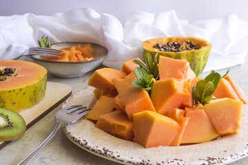 sliced papaya fruit on white plate and in bowl. Fruits for healthy eating.