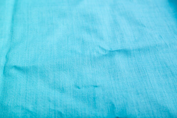 Obraz premium Fragment of smooth cotton blue tissue. Side view, natural textile background.