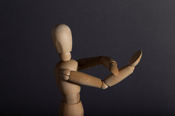 Wooden mannequin shows obscene gesture fuck off with hands on gray background. protest, riot,...