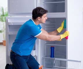 Man cleaning fridge in hygiene concept