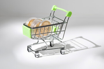 Bitcoin coins in a mini cart from the supermarket. Cryptocurrency.