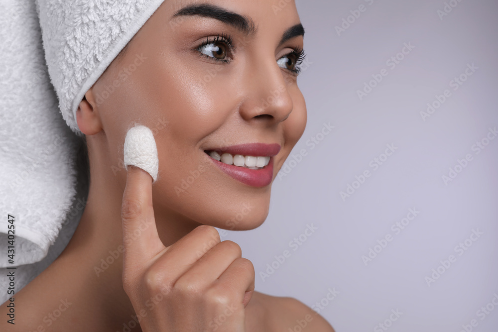 Poster woman using silkworm cocoon in skin care routine on light grey background, closeup. space for text