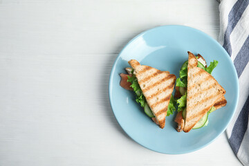 Blue plate with tasty sandwiches on white table, top view. Space for text - Powered by Adobe