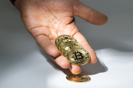 a man's hand shows off a bitcoin coin. cryptocurrency.