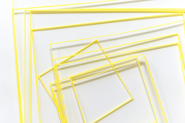 variously sized, yellow PLA filament, 3D printed squares randomly gathered on a white-grey background