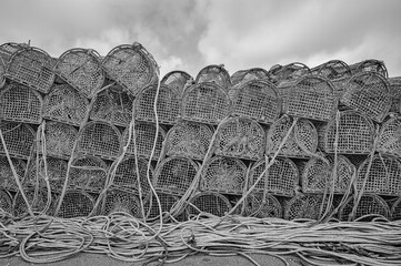 black and white photograph of a group of old fishing pots stacked in piles