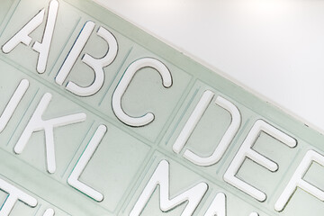 ABC DEF JKL MN alphabetical stencil on a white backlit surface