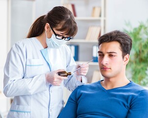Doctor checking patients ear during medical examination