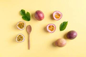 Fresh passion fruit with wooden spoon on yellow background, Flat lay, Top view