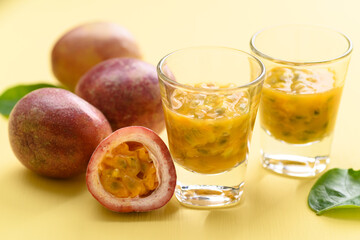 Fresh passion fruit juice in glass on yellow background