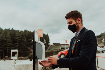 man using wash hand sanitizer gel dispenser adopting to prevent the diffusion of the coronavirus