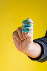 Hand showing a stack of blueberry vanilla french macarons 