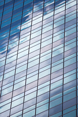 Modern skyscraper blue windows glass wall with reflections.