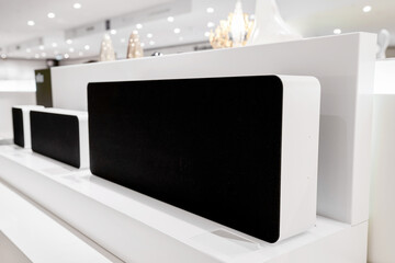 Modern white stereo sound speaker in store shelf, digital loudspeaker