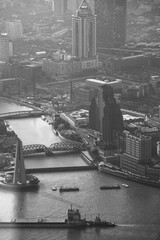 SHANGHAI, CHINA, APRIL 10: Aerial view of the Huangpu river, buildings and boat , taken from the Jimnao Tower in Shanghai. Black and white - Visible noise.