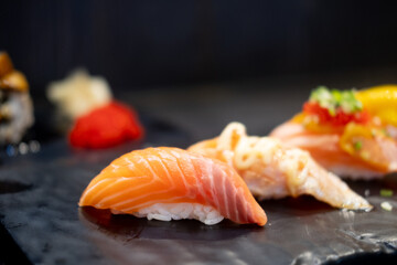 Salmon sushi on black tray