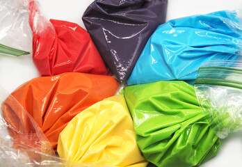 Piping bags with multicolored icing for cake decoration. Isolated on white background