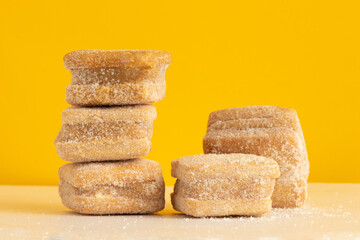 Petit four with dulce de leche on yellow background.