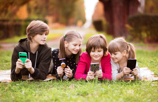 Smartphone addiction group of little children watching film movie cartoon together on digital tablet. Kids playing with phone together