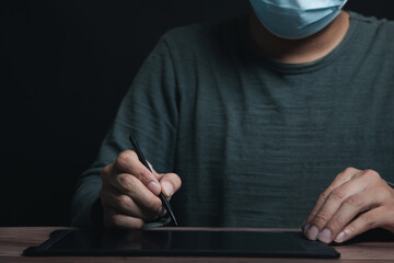 A young man's hand touched on a tablet, modern technology concept, empty space for text, studio photo on a black background.
