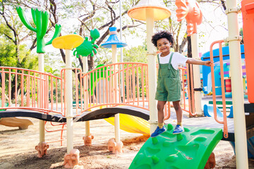 Cute African American little kid boy funny while playing on the playground in the daytime in the spring season. Outdoor activity. Playing make-believe the concept. Outside education