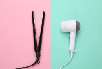 White hair dryer and hair straightener on pink blue pastel background. Beauty concept. Top view. Flat lay