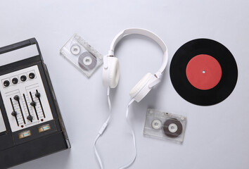 Stereo headphones, vinyl record, audio cassette and audio player with equalizer on a gray...