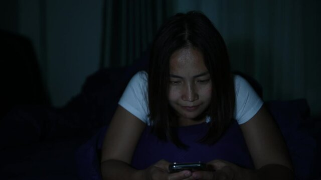 Asian woman play smartphone in the bed at night,Thailand people,Addict social media,Play internet all night	
