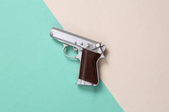 Video game gun on blue beige background. Gaming concept. Top view