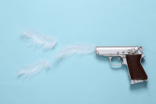 Creative layout minimal composition of video game gun and feather on blue background