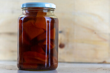 Glasses of jam with homemade pumpkin jam on wooden background