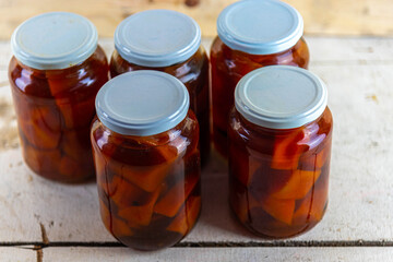 Glasses of jam with homemade pumpkin jam on wooden background