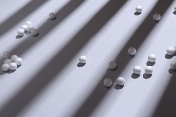 Minimalistic still life. Balls with long trendy striped shadows on gray background. Abstraction, concept art