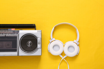 Flat lay music still life. Audio cassette player and headphones on yellow background. Musical concept. Top view.