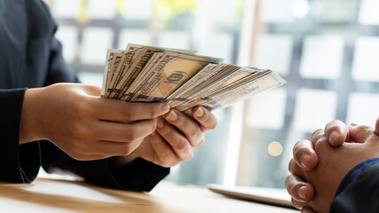 The businessman gives or pays his office with US dollar bills (USD) on spending and lending, loans and financial ideas.