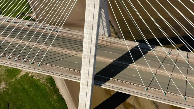 Modern suspension bridge in Wales called Flintshire Bridge. Shot from drone with tight abstract feel tilting up to reveal Welsh town.