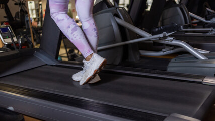 Fototapeta na wymiar Women's feet on a treadmill. Healthy lifestyle concept. Cardio training