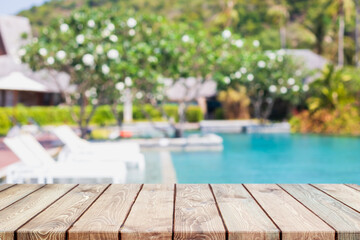 Empty wood table top and blurred swimming pool in tropical resort in summer banner background - can...