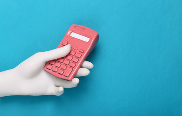 Hand holding Pink calculator on blue background. Minimalism. Creative layout. Fresh idea.