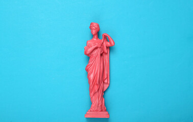 Creative layout. Pink Antique greek goddess statue on blue background. Flat lay. Top view