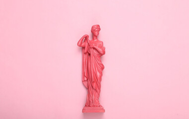 Creative layout. Pink Antique greek goddess statue on pink background. Flat lay. Top view