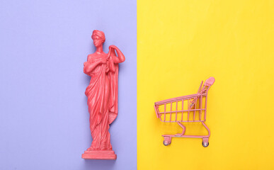 Creative layout. Pink Antique greek goddess statue with shupermarket trolley on purple yellow...