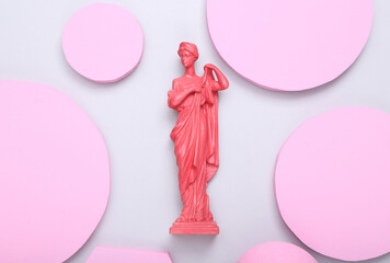 Creative layout. Pink Antique greek goddess statue with circles podiums on gray background. Minimalism. Flat lay. Top view. Flat lay