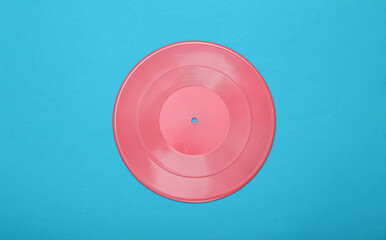 Creative music layout. Pink vinyl record on blue background. Minimalism. Flat lay. Top view. Flat lay