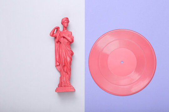 Creative lmusic ayout. Pink Antique greek muse statue with vinyl record on purple gray background. Inspiration. Minimalism. Flat lay. Top view. Flat lay