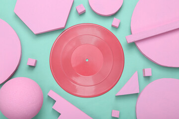 Creative music layout. Pink vinyl record with different geometric shapes on mint blue background. Minimalism. Concept art. Flat lay. Top view.