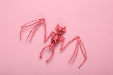 Creative halloween layout. Pink bat skeleton on pink background. Minimalism. Concept art. Fresh idea. Flat lay. Top view.